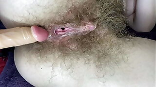 Hairy girl fucks her wet big clit pussy with dildo in close up